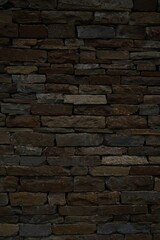 Fototapeta premium Old stone wall texture background Dark brown brick stone masonry close up Rustic stone wall pattern for design