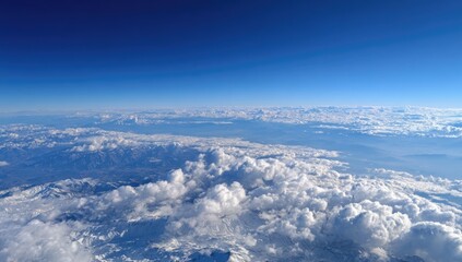 Naklejka premium High-altitude view of clouds, mountains, and a vast blue sky
