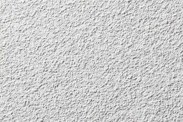 Fototapeta premium Close-up view of a textured, light gray stucco wall. The surface is covered in small, uneven bumps creating a rough, granular appearance