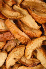 A close-up full frame view of dried apples reveals their rich texture and warm, brownish tones