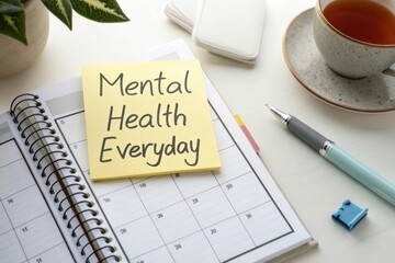 Inspirational Desk Setup for Mental Health Awareness with Planner, Sticky Note, Tea, and Stationery Items
