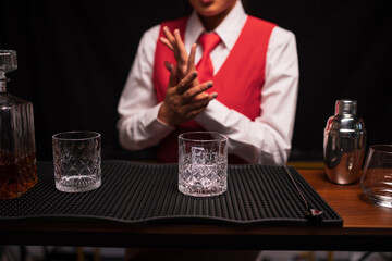 Bartender woman pours whiskey into a glass in a restaurant.	