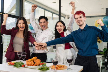 business team are excited business success with inspiration from their excellent financial results, celebration successful deal with champagne and pizza in the workplace.