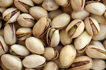 Fototapeta premium Many tasty unpeeled pistachios top view flat lay background pattern