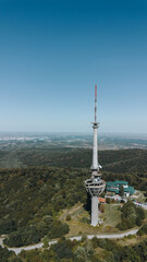 Obraz premium Aerial view of TV tower Iriski Venac rising above the forested hills of Fruska Gora National Park with panoramic landscapes. Was damaged by a NATO missile during the Yugoslav War