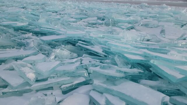 Aerial close to incredible ice hummocks, shining ice toros on frozen Lake Baikal, Siberia. Arctic ice formations and permafrost showcasing climate patterns in pristine untouched nature during winter