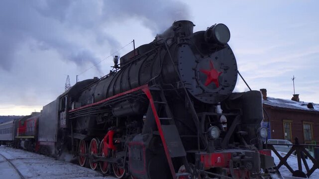 Gimbal historic Soviet steam locomotive on Circum-Baikal Railway in Siberia. Authentic steel details releasing steam in frosty winter air, preparing for scenic journey along Lake Baikal. Epic travel