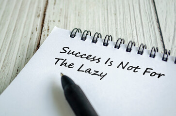Success is not for the lazy text written on a spiral notepad with cautionary handwriting in black pen.