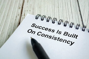 Success is built on consistency text written on a spiral notepad with black pen.