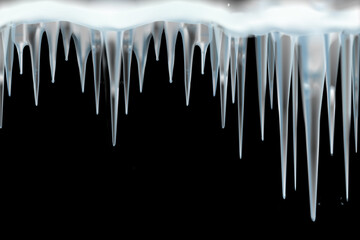line of icy transparent blue icicles on a black background.Close-up