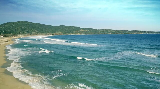 Beautiful seaside scenery, sandy beach waves washing ashore, blue water, sunny