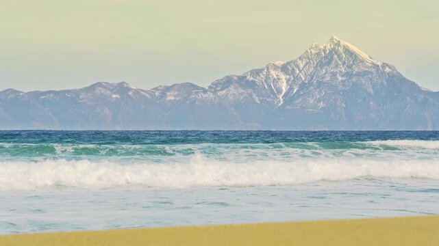 Beautiful waterscape holy mountain Athos horizon sea waves rolling golden sand