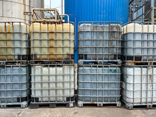 In an industrial setting, stacked storage tanks or IBC tanks showcase various liquids and diverse materials inside