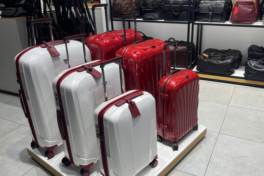 red and white suitcases in the store, the concept of choosing and buying a suitcase