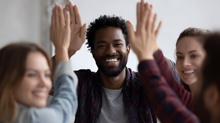 Diverse team celebrating success with high fives in a modern office environment