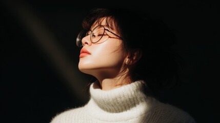 Serene Young Woman in White Sweater with Glasses in Soft Light