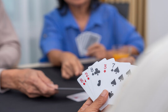 senior friends enjoy playing cards game at home,concept elderly people activity, entertainment,recreation,encourages social interaction,help memory retention