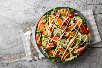 Buffalo Chicken Salad is packed with flavor and tons of healthy ingredients like crunchy veggies, avocado, chopped chicken, and bleu cheese dressing closeup. Horizontal top view from above