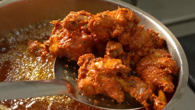 chicken lollipop being deep fried with a spice coating