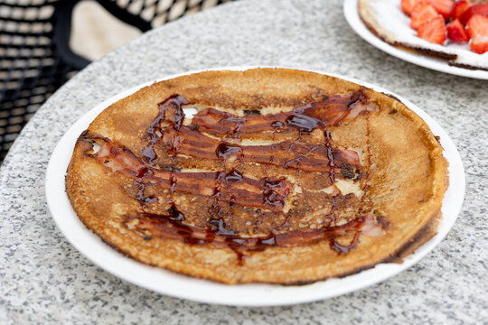 Pannenkoek, or Dutch pancake, is a thin, cr&ecirc;pe-like dish traditionally served warm with savory toppings such as bacon and syrup. A popular typical choice in Dutch cuisine for lunch or dinner.