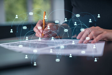Global communication network visualized over businesswoman writing on document.