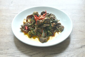 spicy chili stir-fried chicken gizzard and liver couple heartwith basil leaf on plate