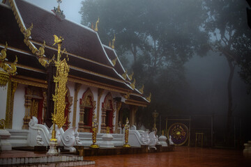 The background of the religious tourist attraction Wat Phra That Doi Tung in the mist in Chiang Rai Province, Thailand, where travelers often stop to make merit.