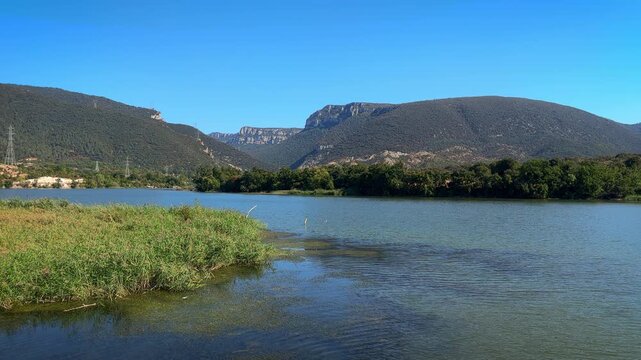Scenic view of the Sobron Reservoir on the Ebro River, located between Alava and Burgos, Spain. Surrounded by green mountains and dramatic rock formations, this water landscape is a popular