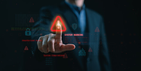 Businessman pressing warning icon on virtual screen with lock, firewall, and binary code, representing system security breach, unauthorized access alert, and cyber risk detection.