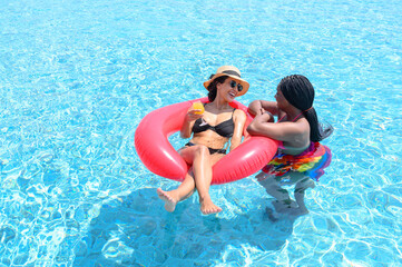 Two woman enjoying in swimming pool. Summer holiday idyllic. Summer vacation concept.