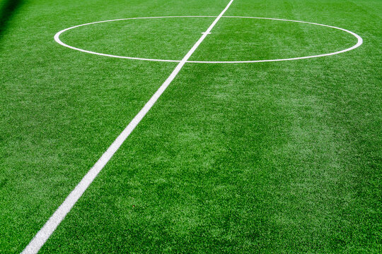 Soccer field with green grass and white line, sport background.