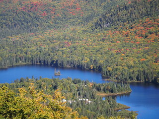 Panoramic view of blue mountain lake with small island in autumn forest