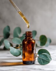 Amber Bottle of Essential Oil with Dropper and Eucalyptus Leaves