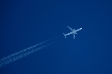 Airplane in the blue sky with contrail. Flight Path Over Blue Sky, travel concept.