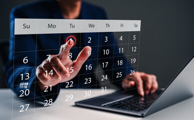 A person interacts with a futuristic digital calendar displayed above a laptop, suggesting modern technology and scheduling.