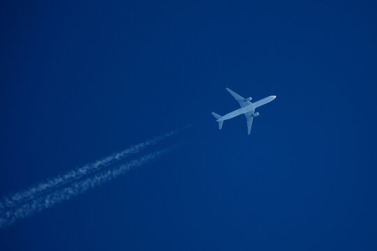 Airplane in the blue sky with contrail. Flight Path Over Blue Sky, travel concept.