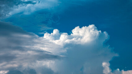 Huge cloudy skies during the day against the blue sky.