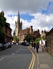 Obraz premium Quaint town street curves past historic church
