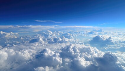 Fototapeta premium High-altitude view of fluffy white clouds against a vibrant blue sky. Vast expanse of cumulus clouds seen from above, with a clear, intense blue backdrop