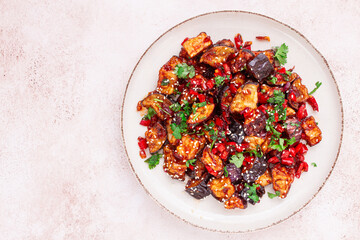 fried eggplant, Chinese style, in sweet and sour sauce, with pepper and sesame seeds. on a white plate,