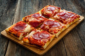 Pizza pepperoni with salami, tomato sauce and mozzarella cheese on wooden table	