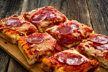 Pizza pepperoni with salami, tomato sauce and mozzarella cheese on wooden table	
