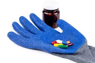 Blue protective glove with colorful capsules and medicine bottle isolated on white background with clipping path.