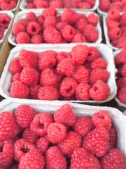Fresh raspberries in containers at the market