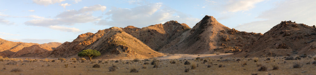 Panorama view of the arid mountains in the Richtersveld desert with summer clouds in the sky