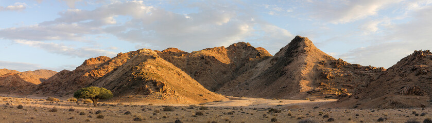 Panorama view of the arid mountains in the Richtersveld desert with summer clouds in the sky