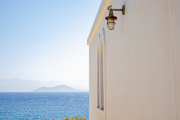 Traditional whitewashed Greek chapel with blue details by the sea
