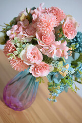 A photograph of beautiful flowers arranged in a vase, taken indoors