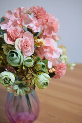 A photograph of beautiful flowers arranged in a vase, taken indoors