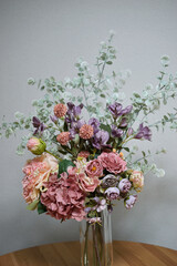 A photograph of beautiful flowers arranged in a vase, taken indoors